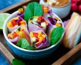 Frische Sommerrollen mit buntem Gemüse, Minze und einer Limettenspalte. Ein leichtes Sommerrollen Rezept für heiße Tage.