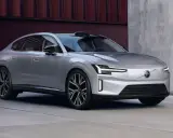 La nouvelle Volvo ES90, une berline électrique argentée aux lignes épurées, se gare devant un bâtiment moderne.
