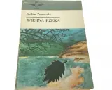 Okładka książki Stefana Żeromskiego "Wierna rzeka". Malownicza ilustracja przedstawia drzewo nad wodą, symbolizującą wierną rzekę.