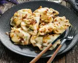 Pyszne pierogi, jak przygotować mrożone pierogi, podane na talerzu z zasmażoną cebulką.
