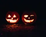 Två lysande pumpor med läskiga ansikten lyser upp mörkret. En perfekt syn för en halloween dag.