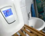 Moderner durchlauferhitzer 18 oder 21 kW zeigt 45°C an. Im Hintergrund ein Waschbecken.