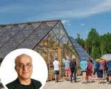 En grupp besökare tittar på ett växthus med solpaneler på taket, en del av auterra solar-projektet.