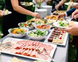 Un délicieux buffet froid avec salades fraîches, charcuteries variées et petits gâteaux colorés, prêt à régaler les convives.