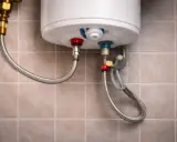 Detalles de cómo cambiar un termo eléctrico: conexiones de agua fría y caliente con mangueras flexibles.