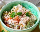 Schüssel mit Reissalat mit Thunfisch, Tomaten, Gurken und Petersilie. Ein leckeres und einfaches Gericht.