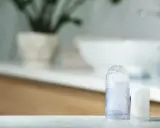 Dwa dezodoranty, jeden przezroczysty z widocznym kryształkiem, drugi biały. Czy ałun jest szkodliwy? To pytanie nurtuje wiele osób szukających naturalnych kosmetyków.