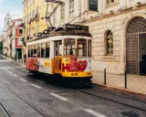 Gelbes Tram fährt durch Lissabon. Perfekt für eine Erkundungstour beim Lissabon wandern.
