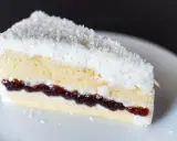 Puszyste ciasto łabędzi puch z warstwą dżemu i wiórkami kokosowymi, idealne na deser.