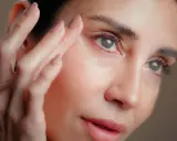 Une femme applique un soin sur son visage. Attention, l'acide hyaluronique peut parfois assécher la peau si mal utilisé.