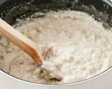 Gęsta owsianka z budyniem, mieszana drewnianą łyżką w garnku.