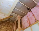 Proceso de como aislar un techo por el interior con lana de vidrio rosa y material de madera.