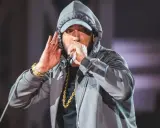 Eminem w kapturze i czapce, z mikrofonem w dłoni, jakby szykował kolejny eminem diss. Złoty łańcuch błyszczy.