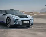 Futuristisches Elektroauto HiPhi Z in silber mit lila Akzenten, steht in einer Wüstenlandschaft vor einer modernen Glasarchitektur.