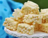 Leckere zuckerfrei leben rezepte: weiße Schokoladenstücke mit knusprigen Reispops auf einem weißen Teller.