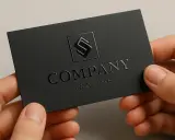 Czarne wizytówki z wypukłym logo i tekstem, prezentujące eleganckie uszlachetnienia druku.