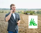 Rolnik rozmawia przez telefon na polu, planując, jak założyć firmę na krusie. W tle kombajn zbiera plony.