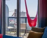Cabina balcone vista parziale MSC con amaca rossa e cuscini accoglienti.