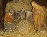Szopka z figurkami: Maryja, Józef, Dzieciątko Jezus, wołek i osiołek. Tekst opowiada o narodzinach.