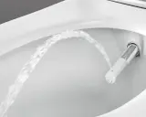 Chorro de agua saliendo de un inodoro moderno, mostrando la función de ducha integrada. Es como si el inodoro tuviera su propio bidet para quitar impurezas.