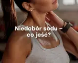 Spocona kobieta po treningu. Tekst: Niedobór sodu – co jeść? Podpowiadamy, jak uzupełnić elektrolity.