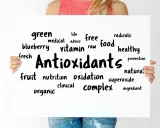 Tablica z napisem "Antioxidants" otoczona słowami kluczowymi, takimi jak "free radicals", "healthy food", "vitamin", "fruit", "blueberry".