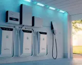 Flera batterier för energilagring på en vägg, en laddstation för elbil och en solcells-inverter. En modern lösning för hur man kan lagra energi.