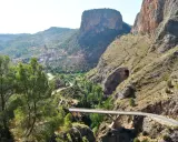Un puente cruza un cañón con un pueblo en la ladera. El **mirador del infierno** ofrece vistas espectaculares de la garganta y las montañas.