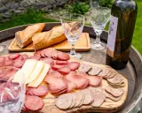 Plateau de charcuterie et fromage, pain frais, verres et bouteille de vin, une spécialité culinaire des Pyrénées.