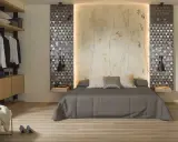 Habitaciones sin cabecero: cama con edredón gris, almohadas y papel tapiz de bambú. A la izquierda, armario abierto con ropa.