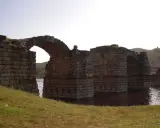 El imponente puente de Alconetar, con sus robustos arcos de piedra, se alza sobre las aguas, testigo de siglos de historia.