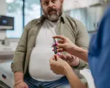 Lekarz mierzy poziom glukozy u pacjenta. Czy przy cukrzycy się chudnie czy tyje? To zależy od typu i leczenia.
