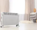 Ein weißer Elektroheizer steht im Wohnzimmer. Er hilft, die strom heizung kosten pro monat im Blick zu behalten.