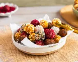 Schüssel voller bunter Energy Balls, perfekt für ein schnelles energy balls rezept. Mit Nüssen, Kokos, Kakao und Beeren verfeinert.