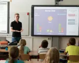 Lehrer präsentiert interaktive Spiele für Vertretungsstunden. Die Klasse spielt ein Quiz, das "Game Over" anzeigt.
