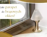 Jaki parapet do brązowych okien? Elegancka lampka nocna stoi na marmurowym parapecie obok okna.