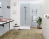 Nowoczesna, biała łazienka z drewnianą podłogą, prysznicem walk-in i różową umywalką.