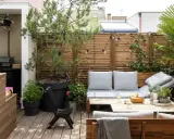 Aménagement terrasse avec pots : un coin salon cosy avec banquette, table basse, et verdure. Parfait pour se détendre.