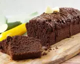 Saftiger schokokuchen mit zucchini, überzogen mit Schokoladenglasur und garniert mit zwei kleinen Herzchen aus hellem Teig.