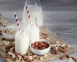 Mleko migdałowe w butelkach i miseczkach z migdałami. Idealne, by czym zastąpić nabiał.