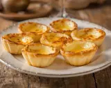 Assiette de délicieux pasteis de nata dorés, leur crème onctueuse invitant à la dégustation.