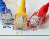Trois câbles Ethernet (CAT5e, CAT6, CAT7) de couleurs différentes, illustrant comment choisir son cable ethernet pour des performances croissantes.