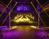 Scenljus och rök fyller en tom lokal i slakthusområdet Stockholm, redo för en kväll med musik och fest.