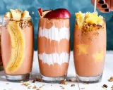 Drei leckere, bunte Smoothies im Glas, garniert mit Früchten und Müsli. Perfekt für den gesunden **Aufbau-Shake** am Morgen.