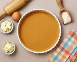 Fond de tarte avec biscuits écrasés sans beurre, prêt pour une garniture gourmande. Ingrédients : œuf, beurre, farine, rouleau à pâtisserie.