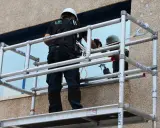 Técnico trabajando en un andamio, revisando las partes de un andamio para asegurar su estabilidad.