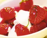 En skål med saftiga, limemarinerade jordgubbar och vispad grädde. En härlig sommardessert.