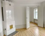 Vitt, vackert kakelugn med mässingsluckor. Tänk att elda i kakelugn en kall vinterdag.