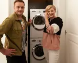 Para prezentuje pralkę i suszarkę w kuchni.