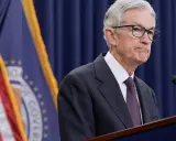 Jerome Powell przemawia na tle flag USA i Rezerwy Federalnej, instytucji, która budzi pytania, czy fed jest prywatny.